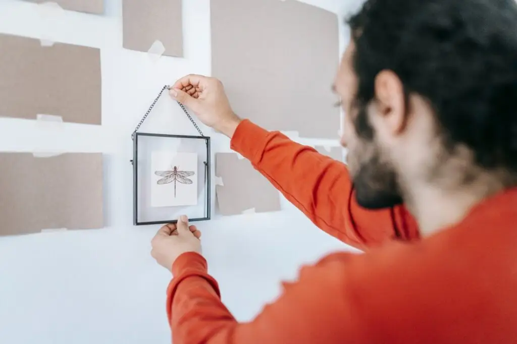 Man Removing A Picture Frame On The Wall